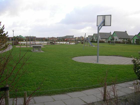 Der Spielplatz mit Basketballkorb und Tischtennisplatte im Vordergrund